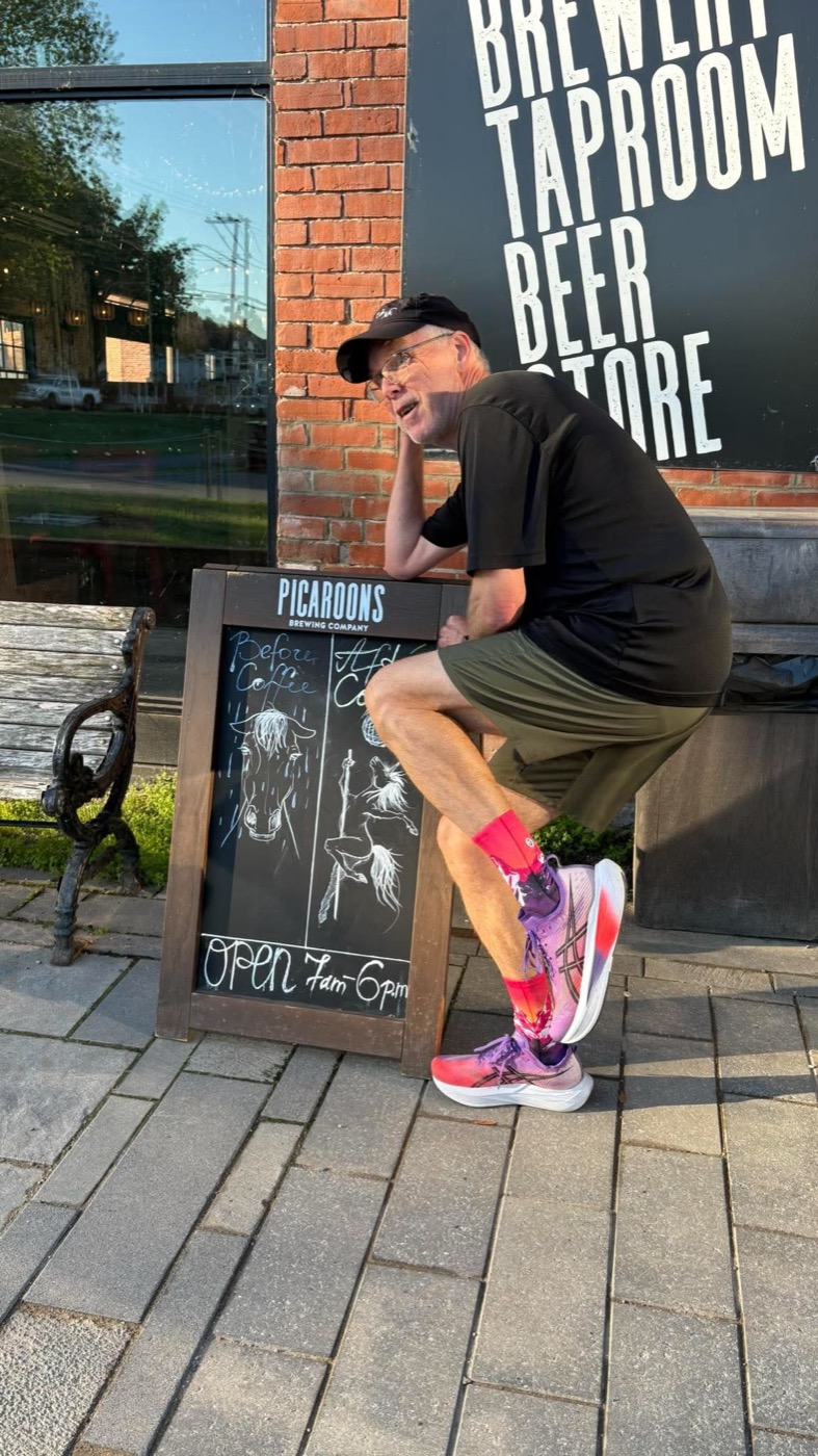 A Devon Deer runner relaxing beside a hand-drawn Picaroons coffee sign after a morning run.